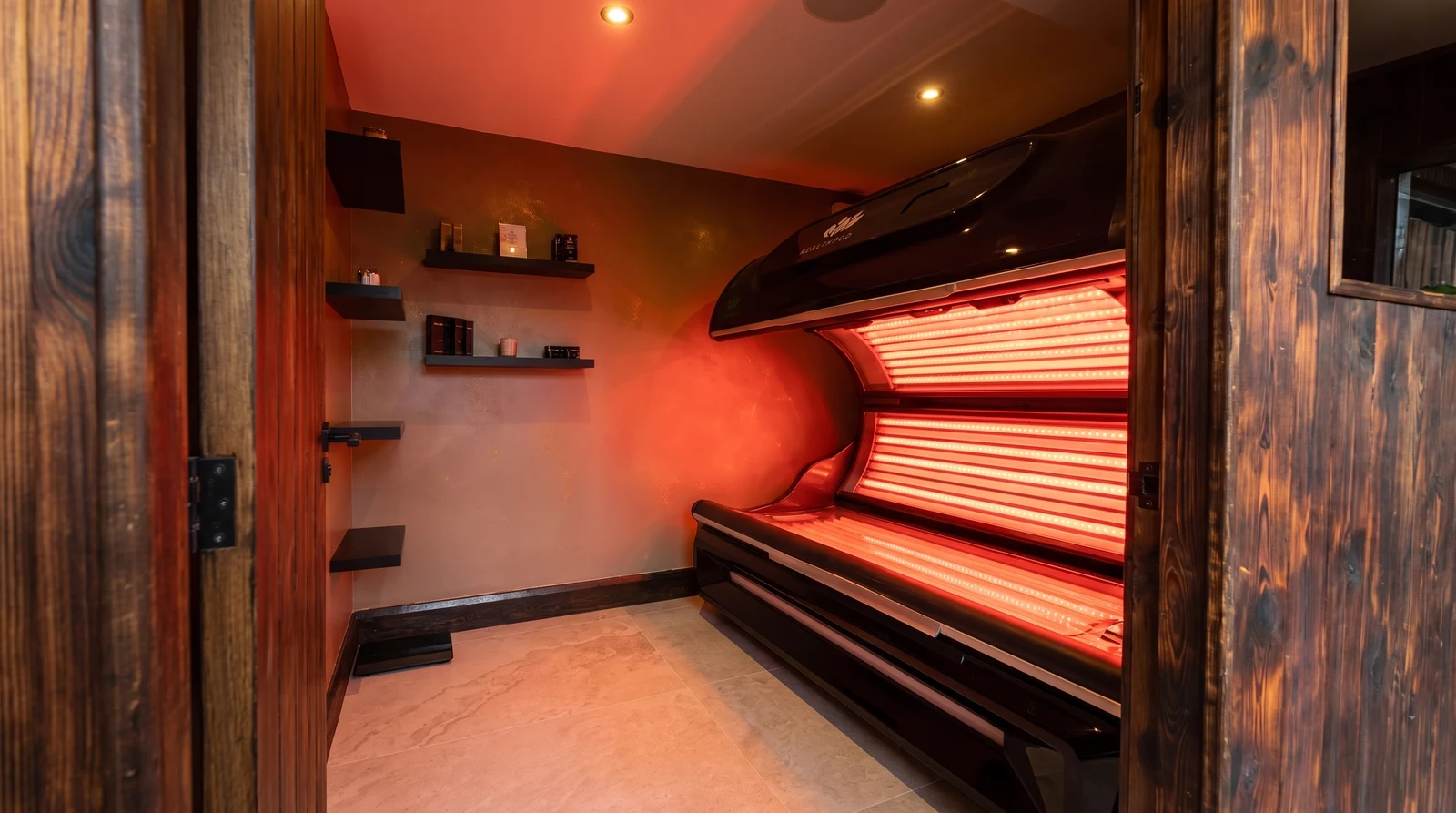 The Health Pod red light therapy room, with the full-body light bed open and its red LED panels lit.