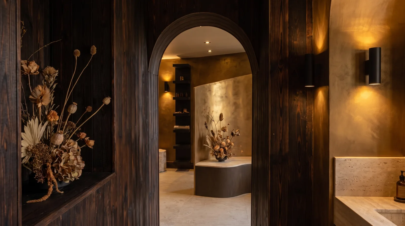 Dried botanical stems set in a niche of dark charred timber.