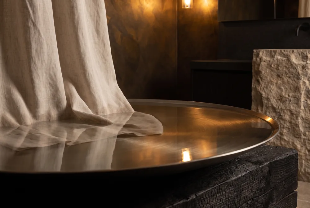 Still water in a round stone basin with draped linen.